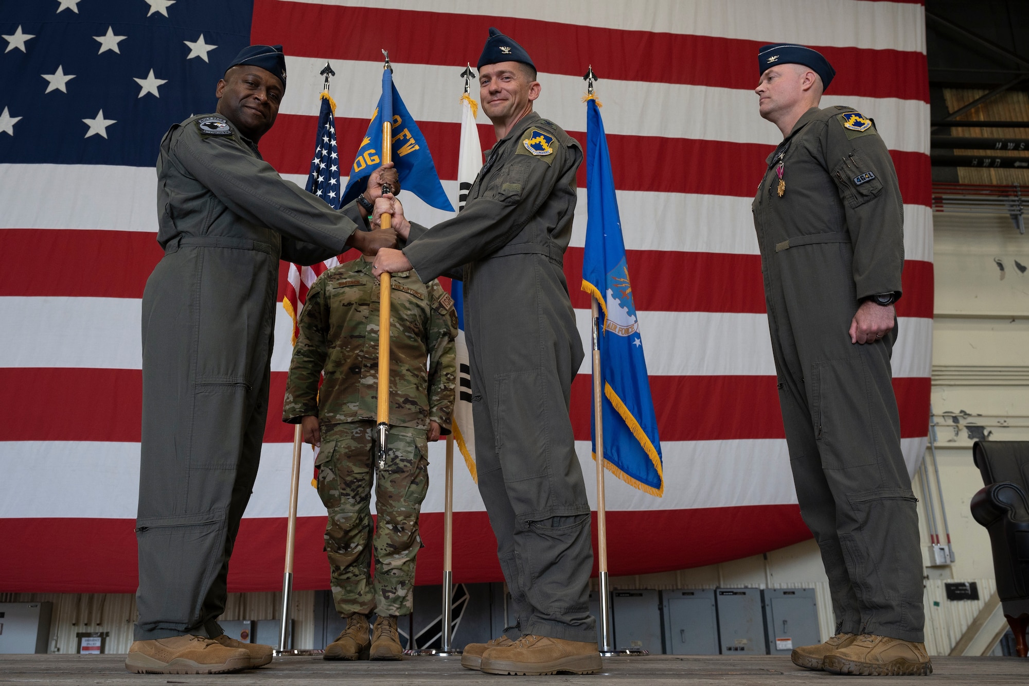 Military members conduct a ceremony with a guidon flag.