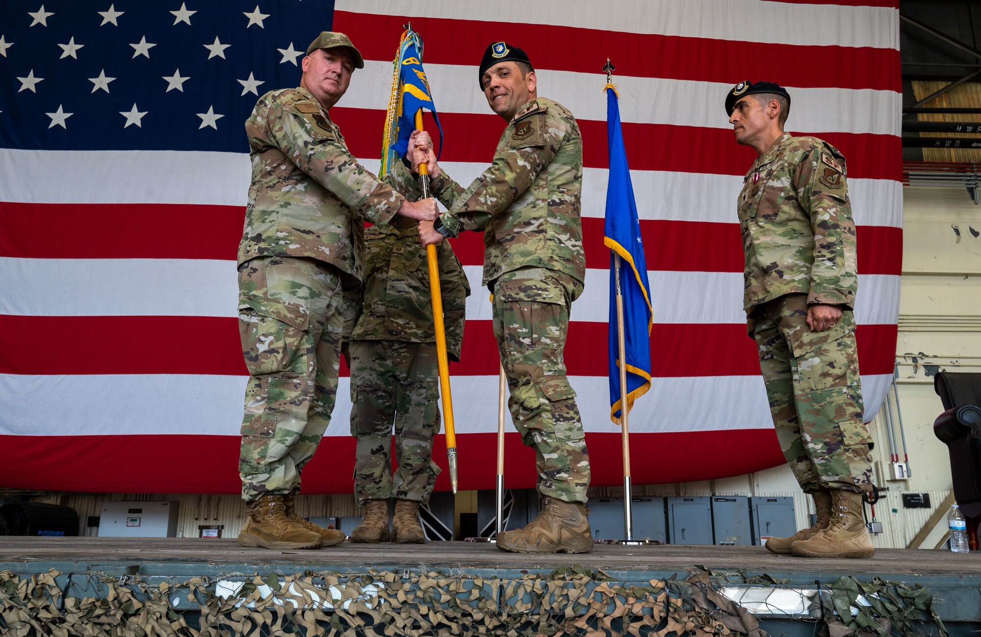 Military members conduct a ceremony with a guidon flag.