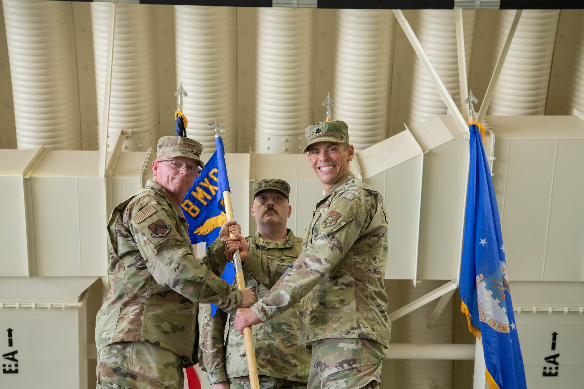 Military members conduct a ceremony with a guidon flag.