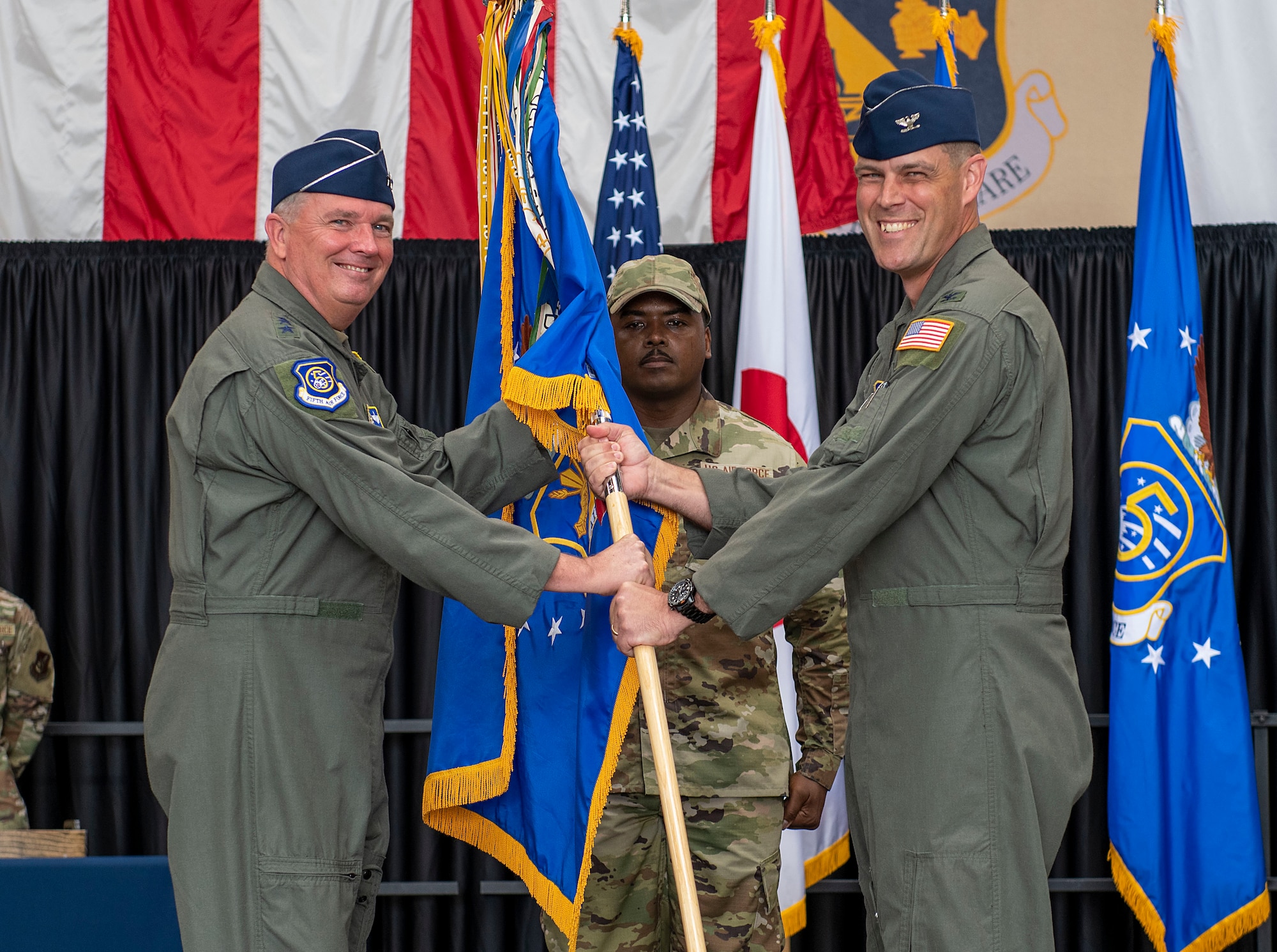 Col. Andrew Campbell, 374th Airlift Wing outgoing commander, passes a guidon to Lt. Gen. Ricky Rupp