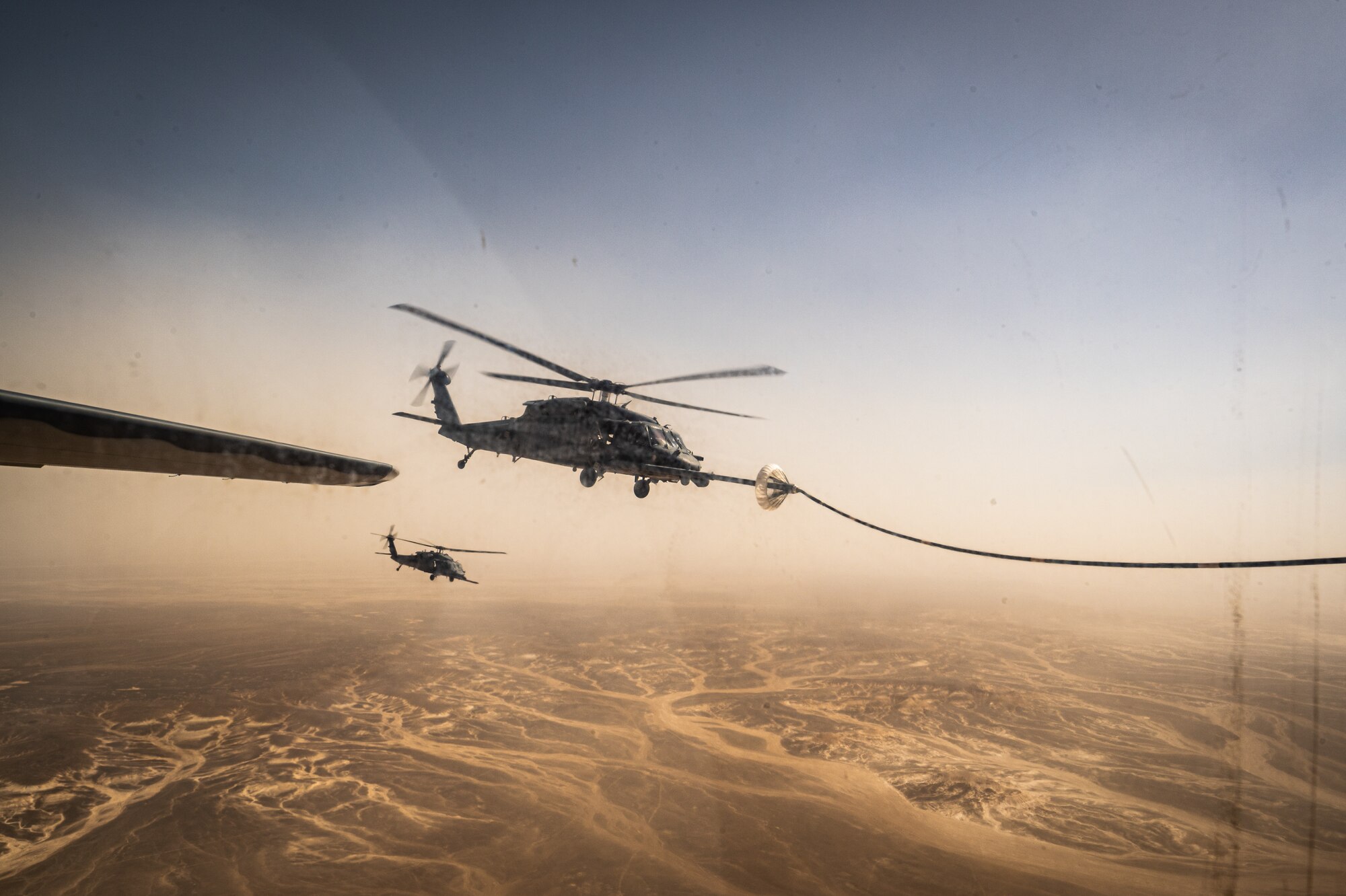 A 332d Air Expeditionary Wing HH-60G Pave Hawk helicopter receives fuel from an HC-130J Combat King II aircraft, also assigned to the 332d AEW, in Southwest Asia June 12, 2022. The primary mission of the Pave Hawk is to conduct day or night personnel recovery operations into hostile environments to recover isolated personnel during conflict. The HH-60G is also tasked to perform military operations other than conflict, including civil search and rescue, medical evacuation, disaster response, humanitarian assistance, security cooperation/aviation advisory, NASA space flight support, and rescue command and control. (U.S. Air Force photo by Master Sgt. Christopher Parr)