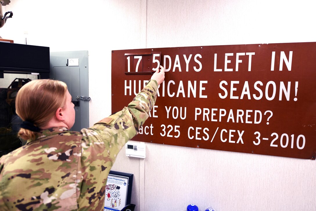Airman changes a number on a wall sign.