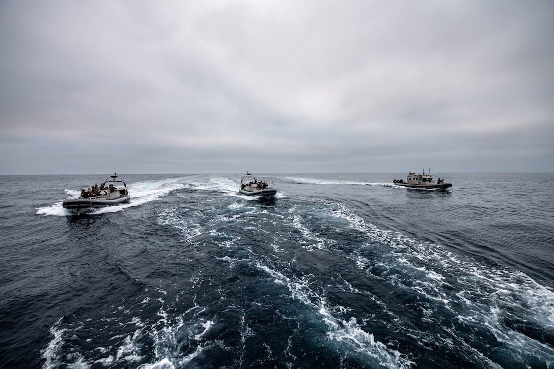 Three small boats move through the water.