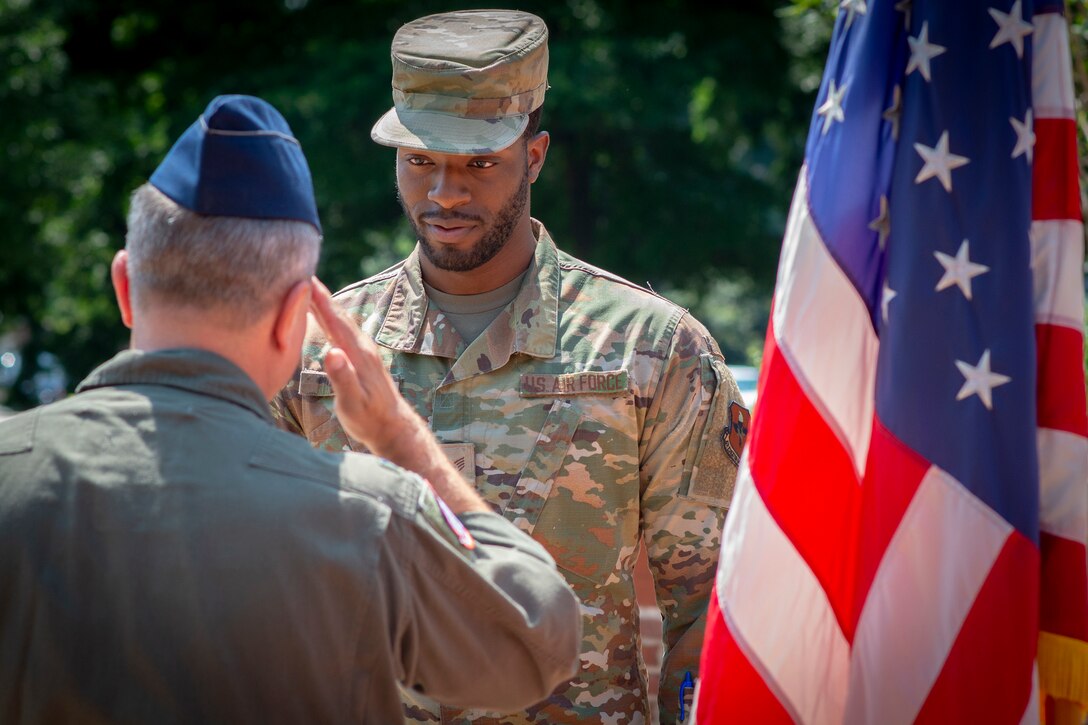 A man salutes another man.