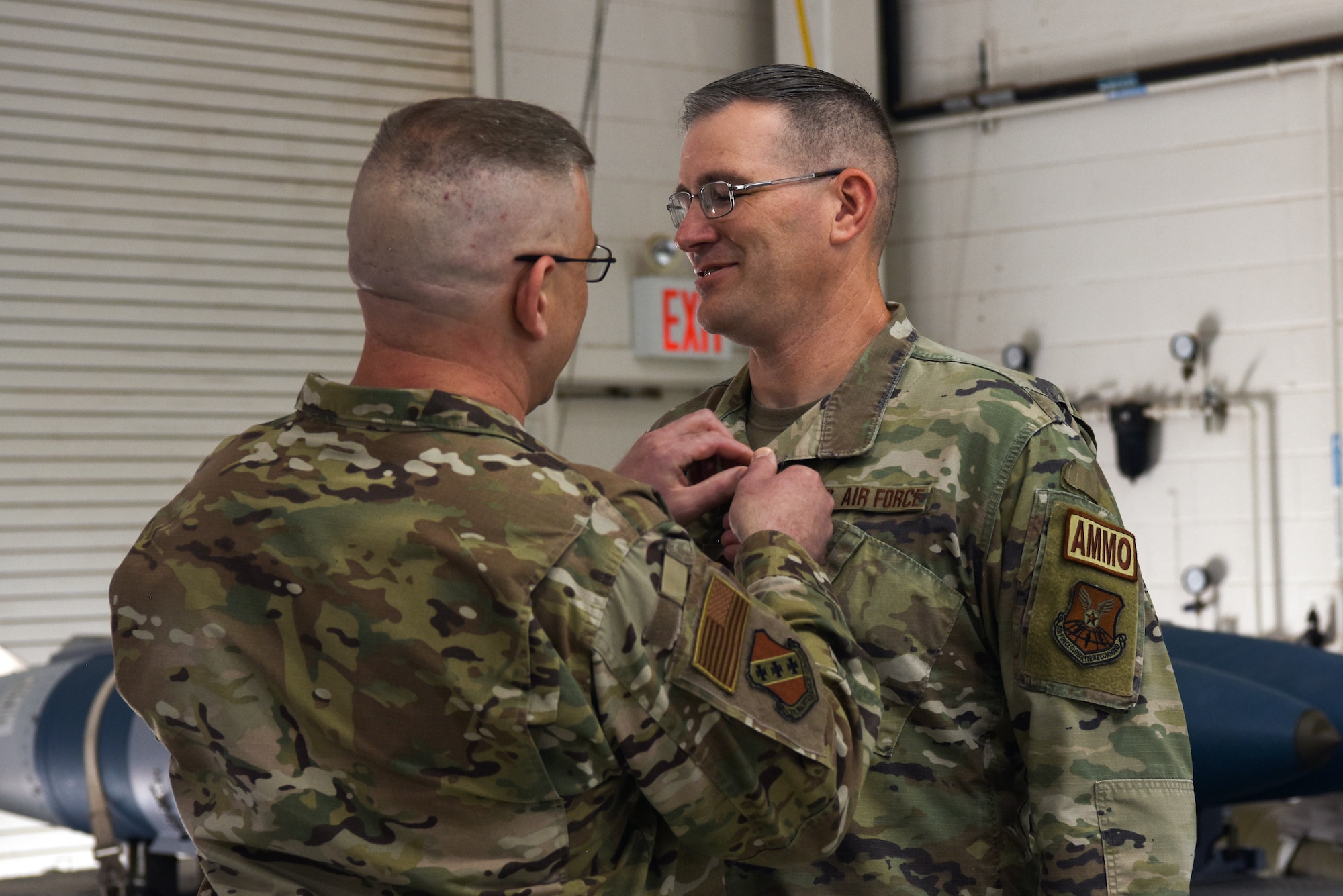 Col. Joshua Pope, 7th Maintenance Squadron commander, clips the Meritorious Service Medal onto Maj. Jeffrey Erwin, outgoing commander of the 7th Munitions Squadron on Dyess Air Force Base Texas, 16 Jun 2022. Erwin oversaw munitions operations for multiple Bomber Task Force deployments during his tenure as commander. (U.S. Air Force photo by Senior Airman Sophia Robello)