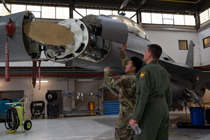 U.S. Air Force Staff Sgt. Jackie Zheng, left, avionics specialist, 113th Wing, District of Columbia National Guard, briefs Lt. Gen. Michael A. Loh, right, director, Air National Guard, on the radar being replaced by the Active Electronically Scanned Array radar now equipped on F-16 Fighting Falcon aircraft assigned to the DCNG on Joint Base Andrews, Maryland, June 9, 2022. The AESA radar brings up-to-date capabilities to this legacy aircraft and enhances the ANG’s integrated defense efforts while remaining interoperable with the Total Force and coalition partners.