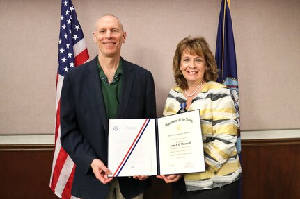 NSWC IHD Technical Director Ashley Johnson presents former NSWC IHD Deputy Technical Director Amy O’Donnell with the Department of the Navy Superior Civilian Service Award. The Navy Superior Civilian Service Award is the second highest U.S. Navy honorary award and recognizes superior civilian service resulting in high value or benefit to the Navy. (U.S. Navy photo by Matthew Poynor)