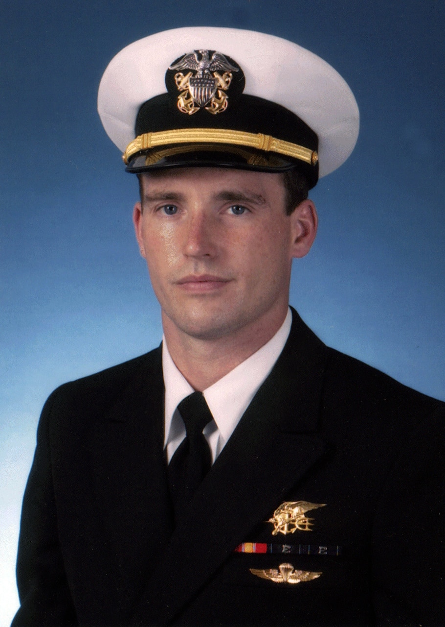 A man in uniform and dress cap poses for a photo.