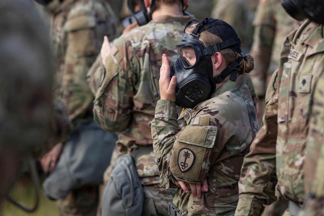 A Soldier assigned to the 447th Military Police Company seals their M50 Joint Service General Purpose Mask during Chemical, Biological, Radiological, and Nuclear training.