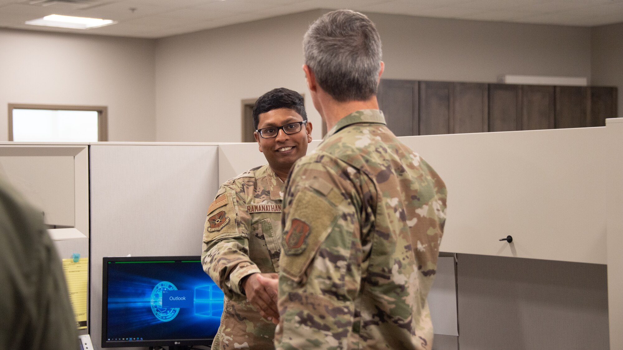 Maj. Gen Bryan R. Radliff (right), 10th Air Force commander, coins Senior Airman Praveen Ramanathan, 301st Fighter Wing Financial Management Office military pay technician at Naval Air Station Joint Reserve Base Fort Worth, Texas, June 5, 2022. Radliff coined Praveen for his exceptional performance within the workplace. (U.S. Air Force photo by Staff Sgt. Nije Hightower)
