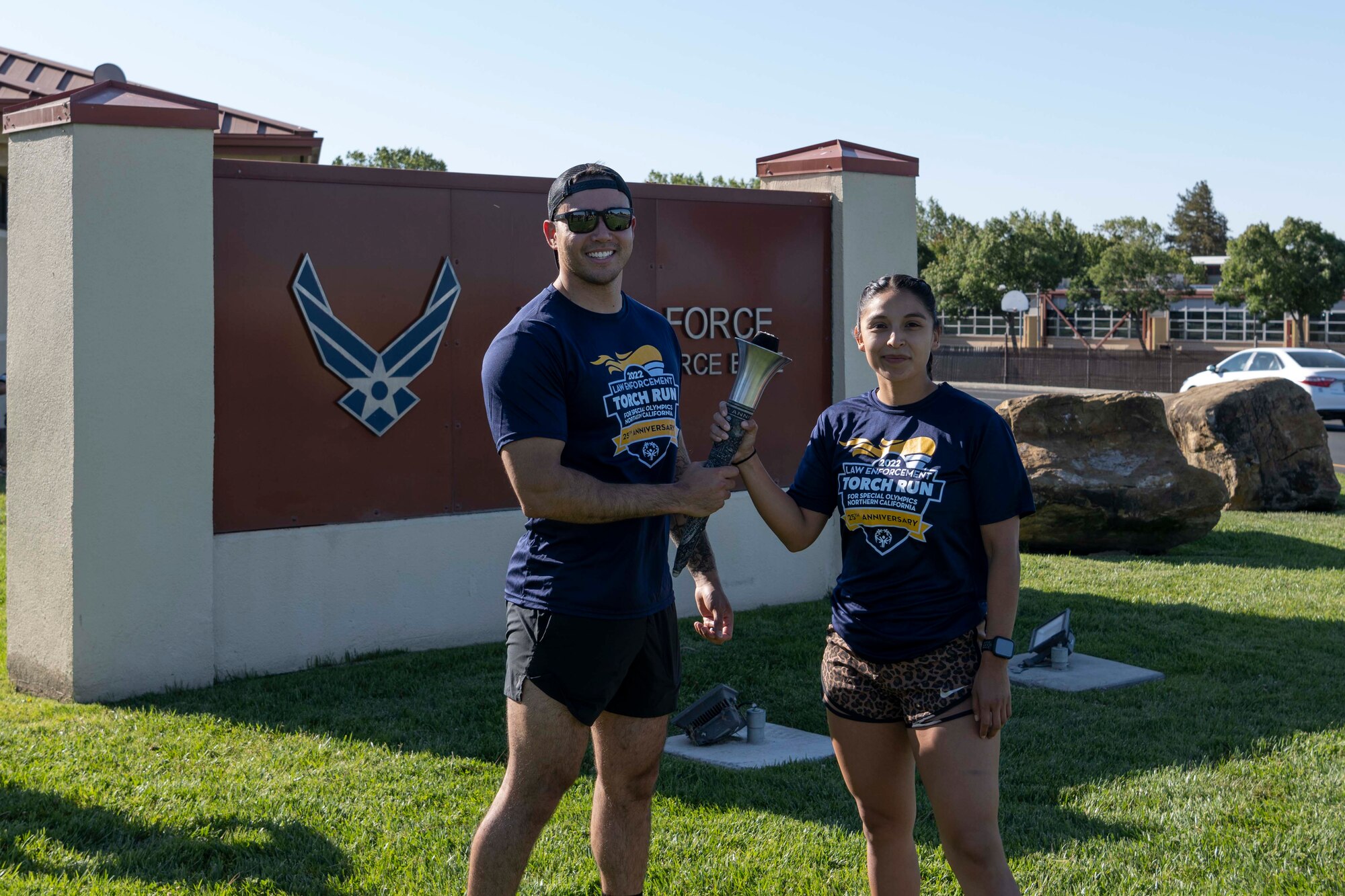 An Airman hands a torch to a Fairfield police officer
