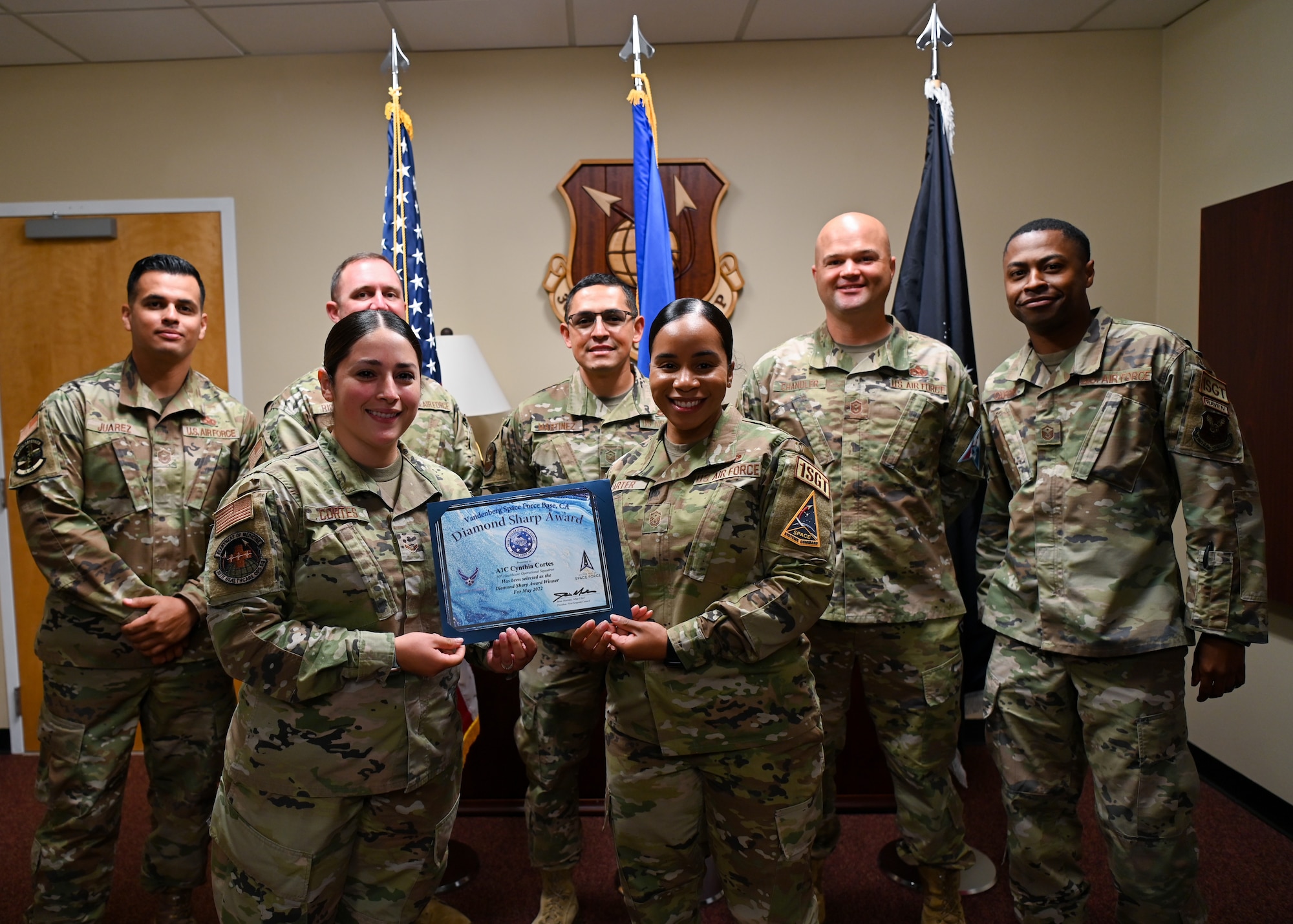 Master Sgt. Ashley J. Carter, 30th Medical Group first sergeant (center), presents the Diamond Sharp Award to Airman 1st Class Cinthia Cortes (left), 30th Medical Group aerospace medical technician at Vandenberg Space Force Base, Calif., June 14, 2022. The Diamond Sharp Award is given to and recognizes exemplary Airmen and Guardians who go above and beyond in their daily lives. Cortes received the award for her quick action heroic efforts to help save an injured motorcyclist’s life while exiting Highway 101 in Santa Maria, Calif. (U.S. Space Force photo by Airman 1st Class Tiarra Sibley)