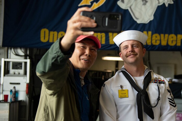 Boatswain’s Mate 1st Class Zachary Miller, assigned to the Zumwalt-class destroyer USS Michael Monsoor (DDG 1001), takes a selfie with a Portland native during Portland Rose Festival and Fleet Week 2022, June 11. Portland Fleet Week is a time-honored celebration of the sea services and provides an opportunity for the citizens of Oregon to meet Sailors, Marines and Coast Guardsmen, as well as witness firsthand the latest capabilities of today's maritime services (U.S. Navy Photo by Mass Communication Specialist 2nd Class Jasmine Suarez).