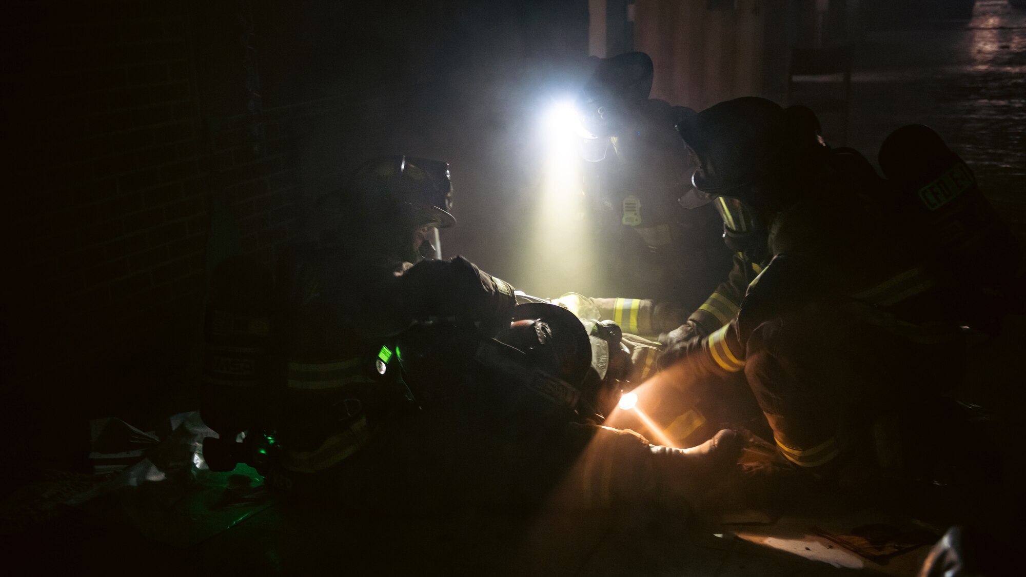 Firefighters secure a downed firefighter.
