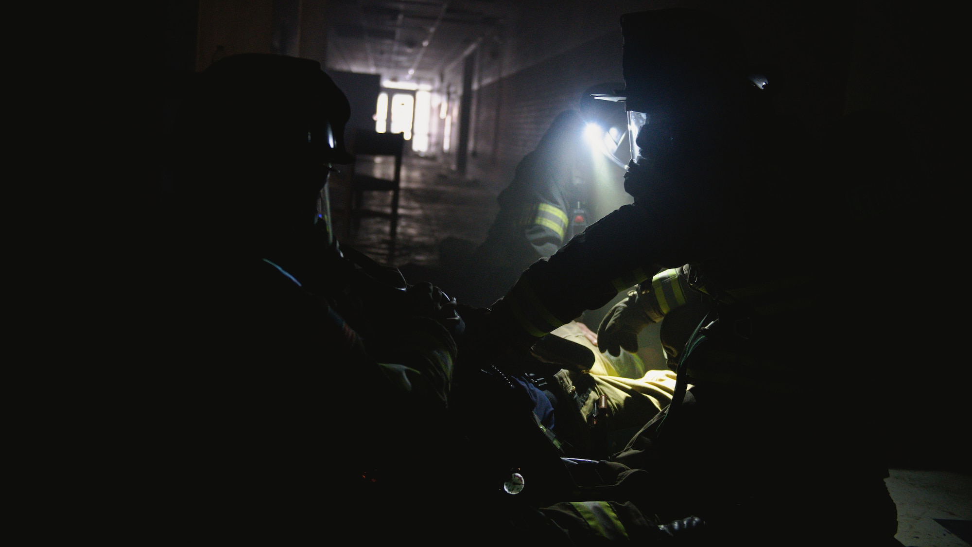 Firefighters take gear off of a downed firefighter.