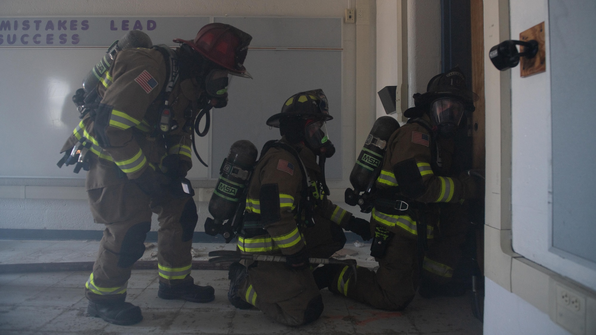 Firefighters prepare to enter a door.