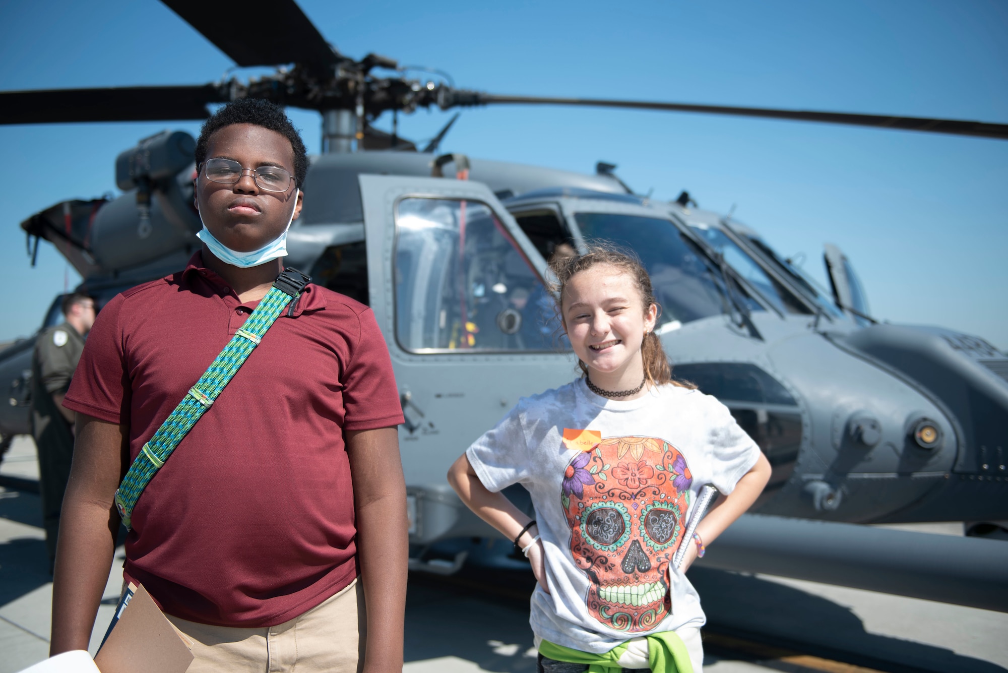 Nicolas, left, and Annabelle, right,pose in front of an HH-60W Jolly Green II helicopter during Teen Shadow Day at Moody Air Force Base, Georgia, June 22, 2022. Nicholas and Annabelle shadowed Moody Public Affairs and gained hands-on experience in interviewing subject matter experts and photography during Teen Shadow Day. (U.S. Air Force photo by Staff Sgt. Thomas Johns)