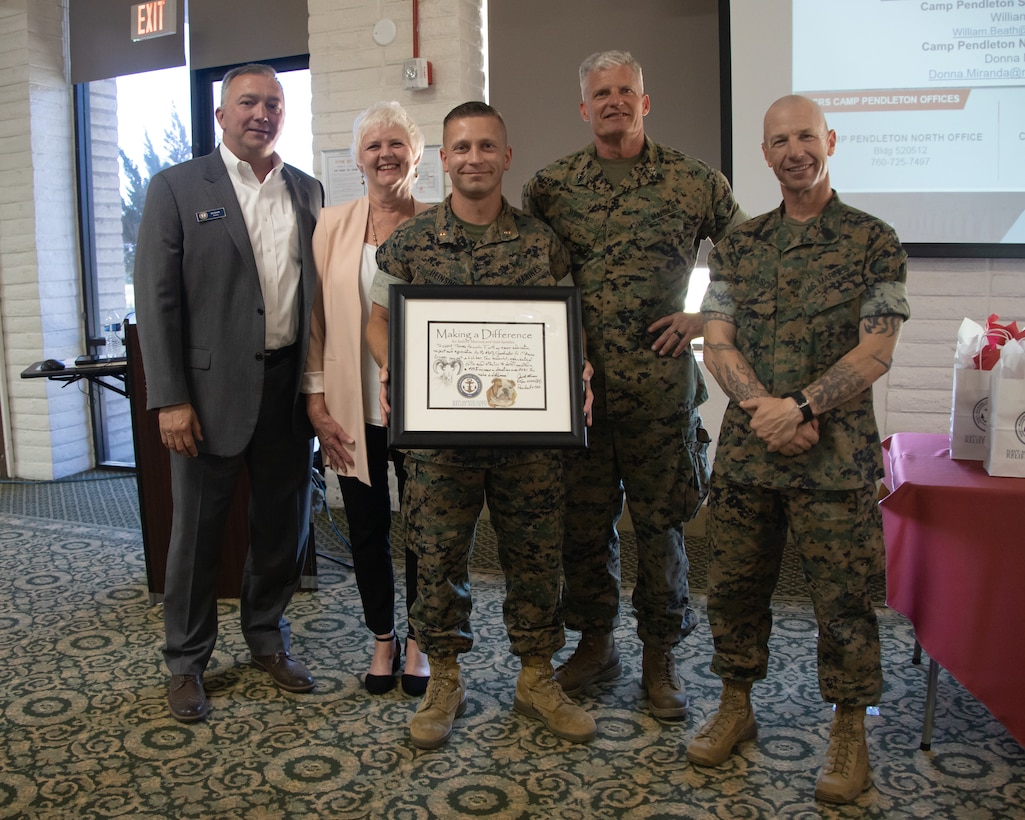 U.S. Marine Corps CWO2 Thomas Heinsohn, a food services officer with 1st Marine Division (1st MARDIV), poses for a photo with Maj. Gen. Roger B. Turner, commanding general of 1st MARDIV (2nd from right), and members of the Navy-Marine Corps Relief Society (NMCRS) during the 2022 Active Duty Fund Drive (ADFD) close out ceremony at Marine Corps Base Camp Pendleton, California, June 21, 2022. At the end of each ADFD season, NMCRS offices from around the world host an appreciation ceremony recognizing commands with the highest donation. (U.S. Marine Corps photo by Lance Cpl. Jaye Townsend)