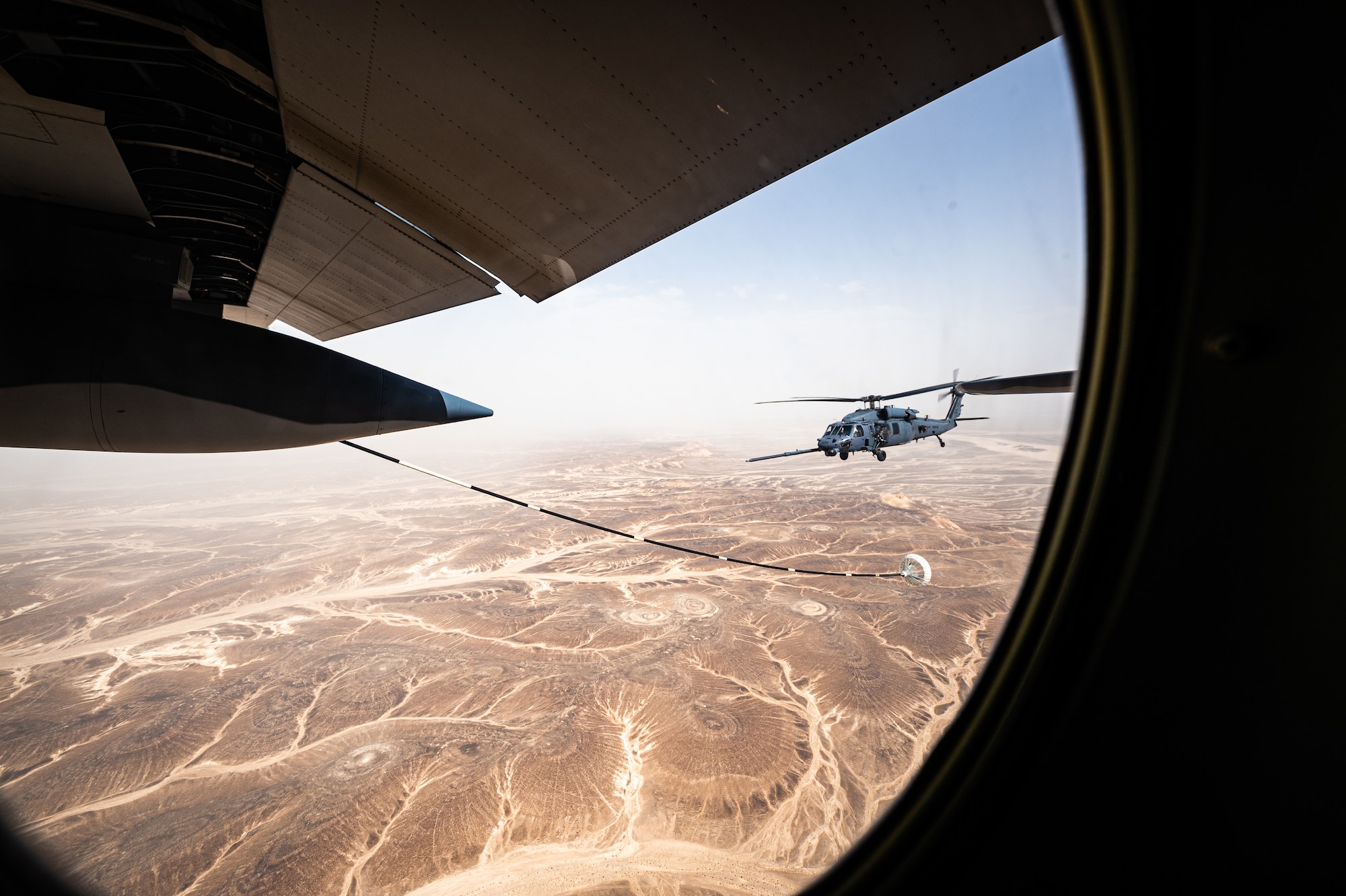 A 332d Air Expeditionary Wing HH-60G Pave Hawk helicopter receives fuel from an HC-130J Combat King II aircraft, also assigned to the 332d AEW, in Southwest Asia June 12, 2022. The primary mission of the Pave Hawk is to conduct day or night personnel recovery operations into hostile environments to recover isolated personnel during conflict. The HH-60G is also tasked to perform military operations other than conflict, including civil search and rescue, medical evacuation, disaster response, humanitarian assistance, security cooperation/aviation advisory, NASA space flight support, and rescue command and control. (U.S. Air Force photo by Master Sgt. Christopher Parr)