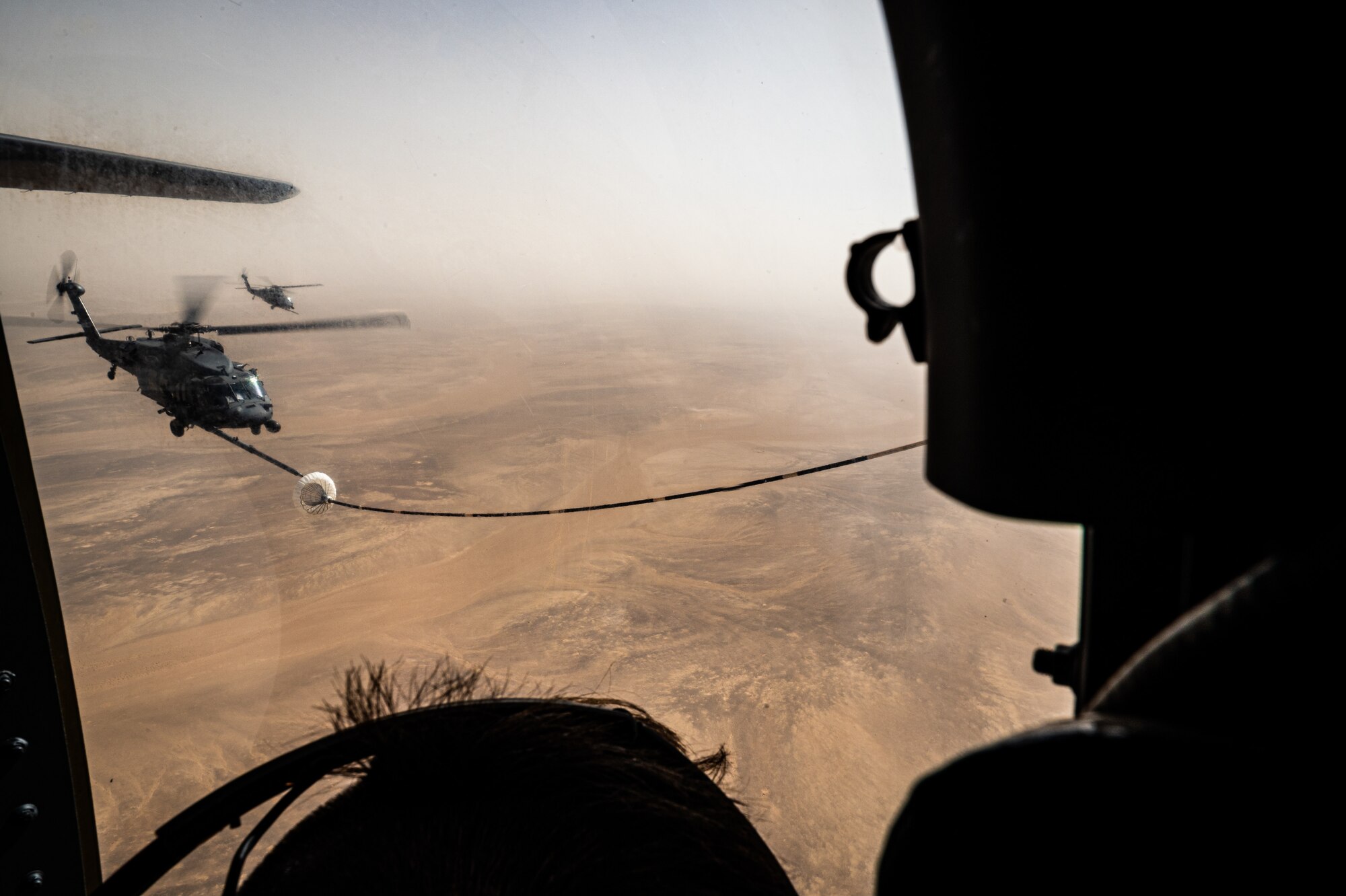 A 332d Air Expeditionary Wing HH-60G Pave Hawk helicopter receives fuel from an HC-130J Combat King II aircraft, also assigned to the 332d AEW, in Southwest Asia June 12, 2022. The primary mission of the Pave Hawk is to conduct day or night personnel recovery operations into hostile environments to recover isolated personnel during conflict. The HH-60G is also tasked to perform military operations other than conflict, including civil search and rescue, medical evacuation, disaster response, humanitarian assistance, security cooperation/aviation advisory, NASA space flight support, and rescue command and control. (U.S. Air Force photo by Master Sgt. Christopher Parr)