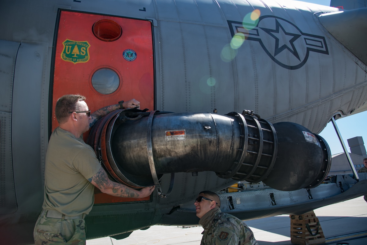 Airmen attach nozzle to plane