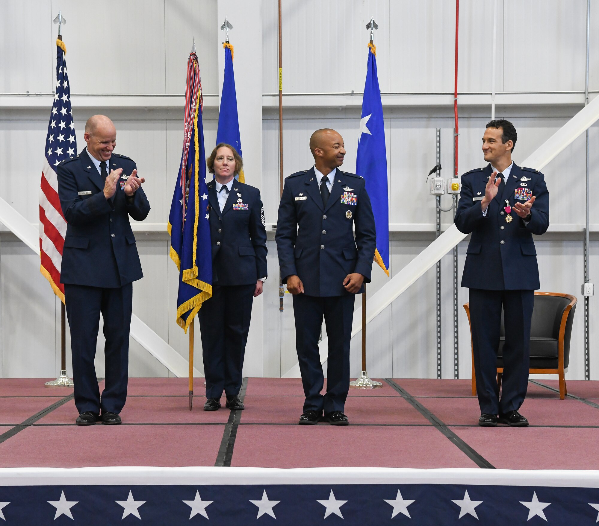 Air Force Test Center Commander Maj. Gen. Evan Dertien, left, and Col. Jeffrey Geraghty, right, previous commander of Arnold Engineering Development Complex, applaud Col. Randel Gordon, center, after he assumed command of AEDC during a Change of Command Ceremony June 16, 2022, in the Aircraft Test Support Facility at Arnold Air Force Base, Tennessee. Also pictured is Chief Master Sgt. Jennifer Cirricione, senior enlisted leader, AEDC. (U.S. Air Force photo by Jill Pickett)