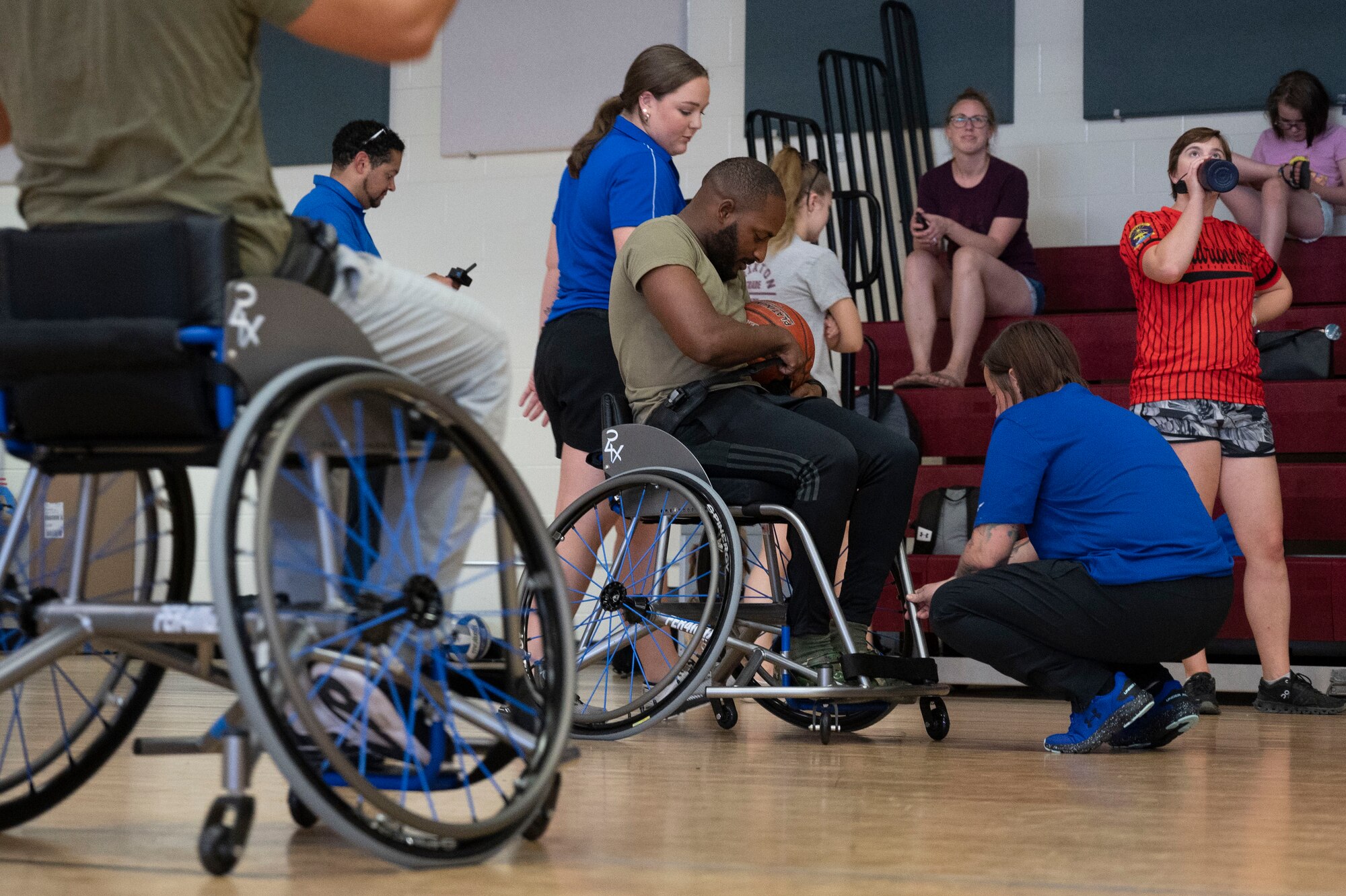 U.S. Airmen prepare to try modified basketball with the help of several Air Force Wounded Warrior
Program (AFW2) members at Laughlin Air Force Base, Texas, June 15, 2022. The AFW2 Program is a
Congressionally-mandated and Federally-funded organization tasked with taking care of U.S. Air Force
wounded, ill, and injured Airmen, Veterans, and their families. (U.S. Air Force photo by Airman 1st Class
Kailee Reynolds)