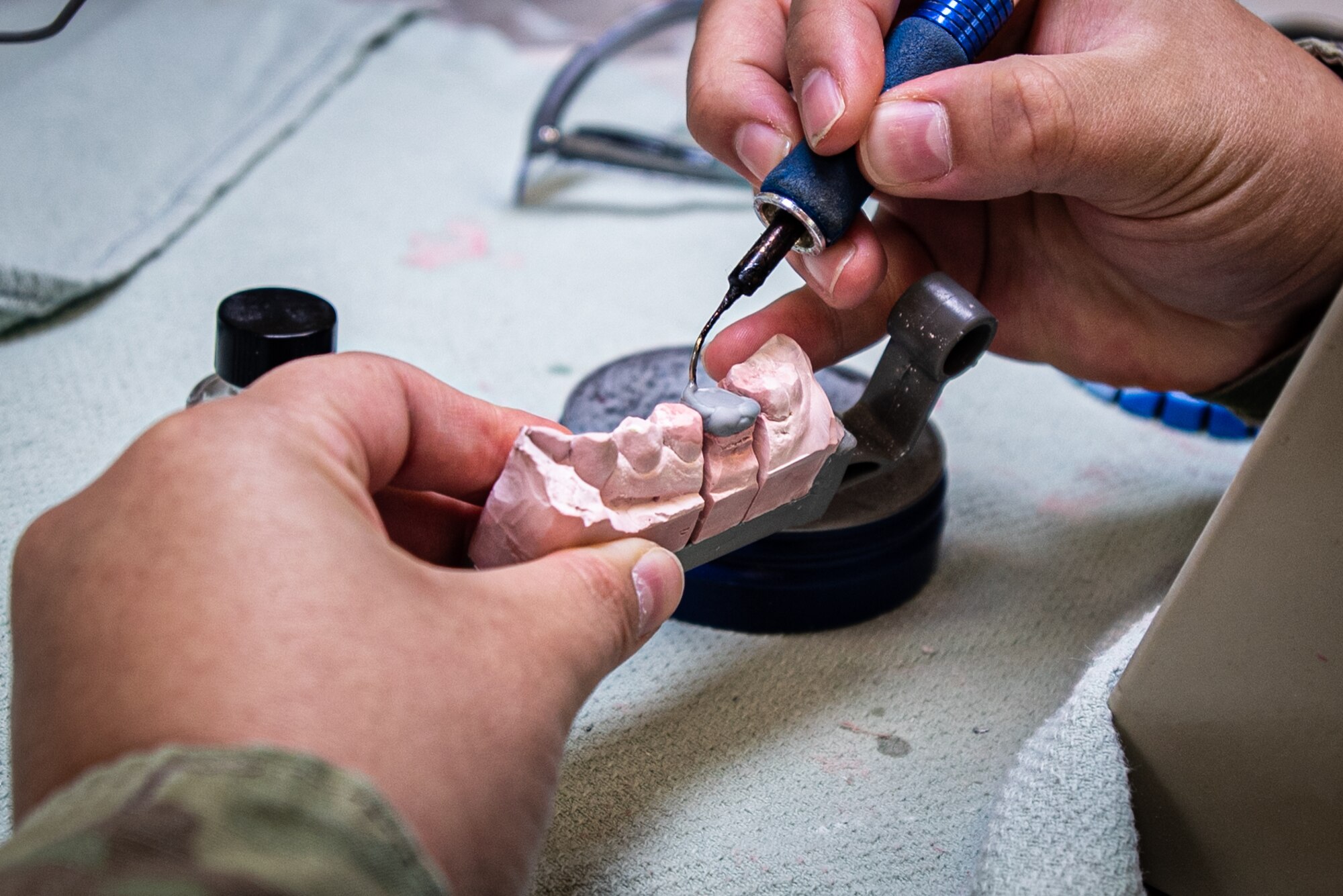 An Airman makes a wax mold for a tooth.