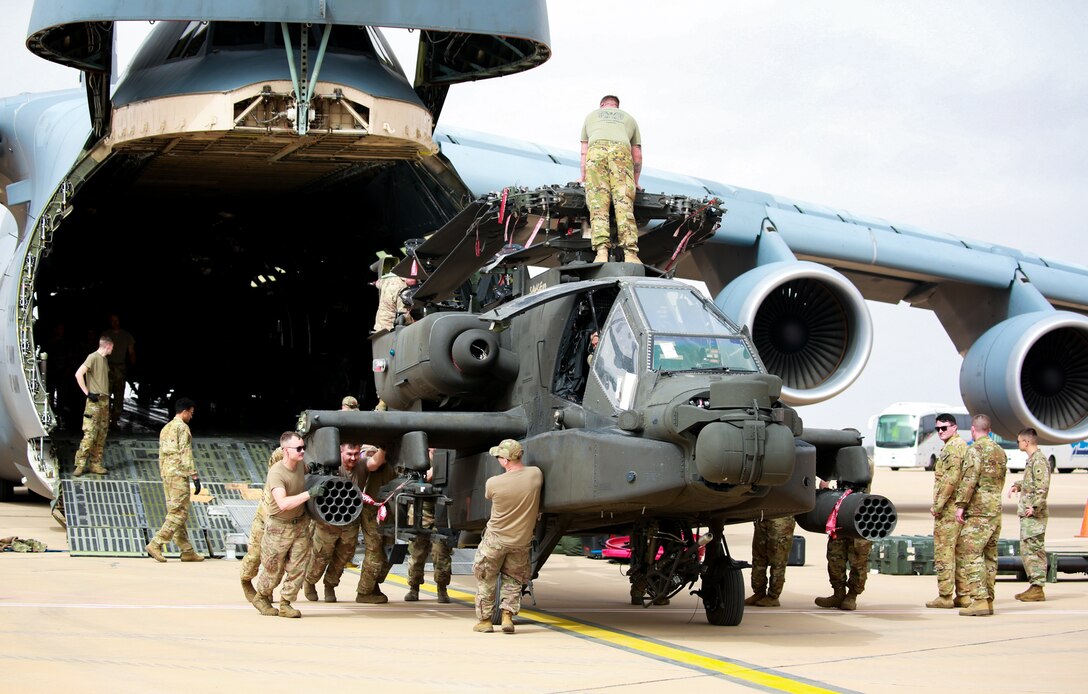 U.S. Soldiers from the 1-211th Aviation Regiment, Utah Army National Guard, unload an AH-64 Apache helicopter on June 20, 2022, at Agadir Al-Massira International Airport, Morocco.