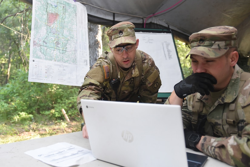 U.S. Army Reserve Staff Sgt. Ian Fairweather, left, Observer Coach Trainer, 1-338th Training Support Battalion, 85th U.S. Army Reserve Support Command, and Staff Sgt. Casey Newtols, Observer Coach and Trainer, 1-338th TSBN, review the 420th Military Police Company’s Standard Operating Procedure during the Spartan Warrior Three training exercise at Fort McCoy, Wisconsin, June 19, 2022.