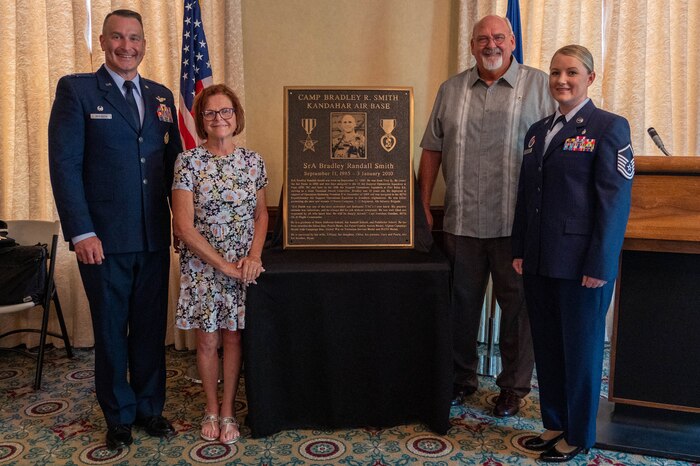 People stand by plaque