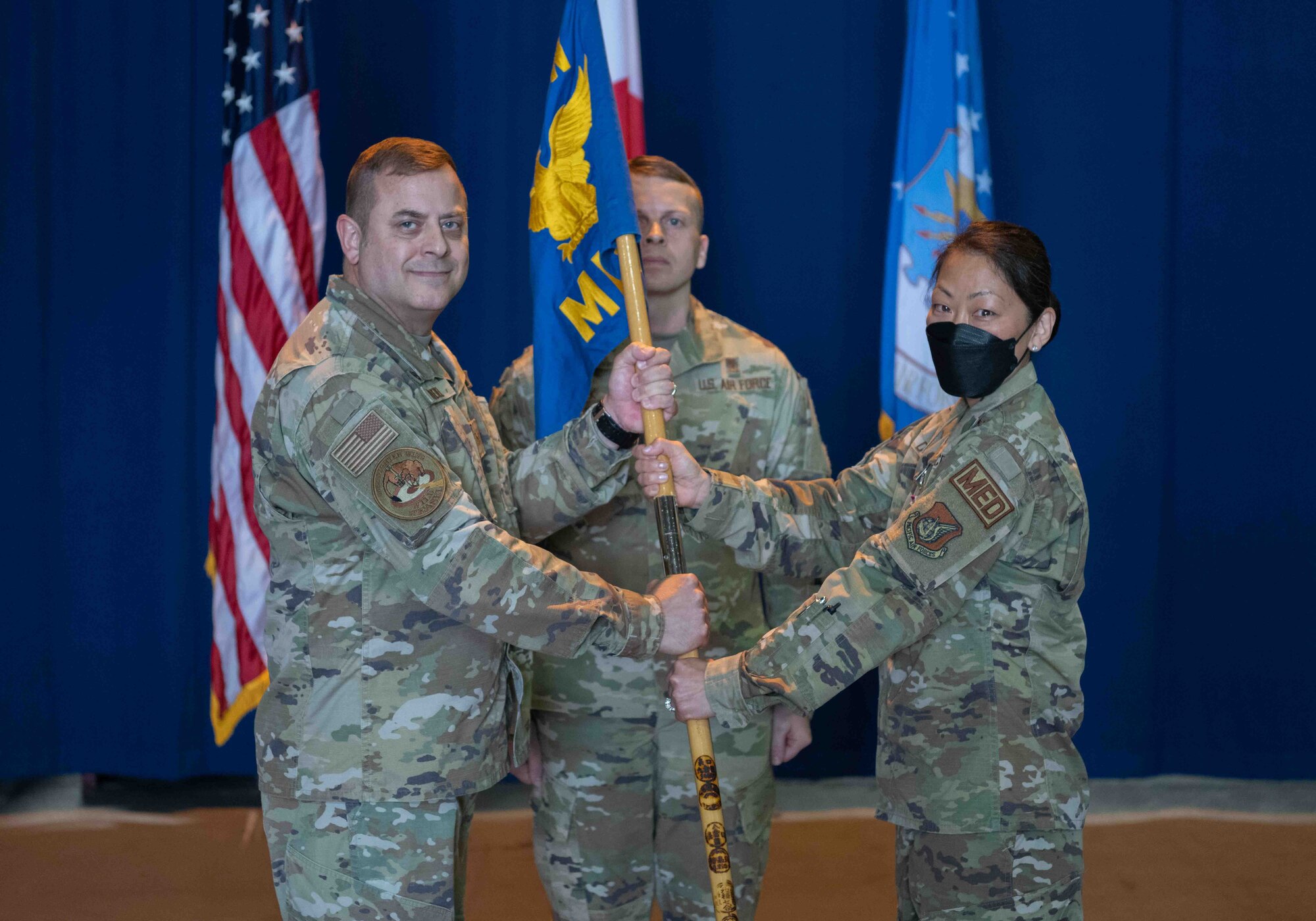 Military members hold on to a guidon as a symbol of assumption and relinquish of command