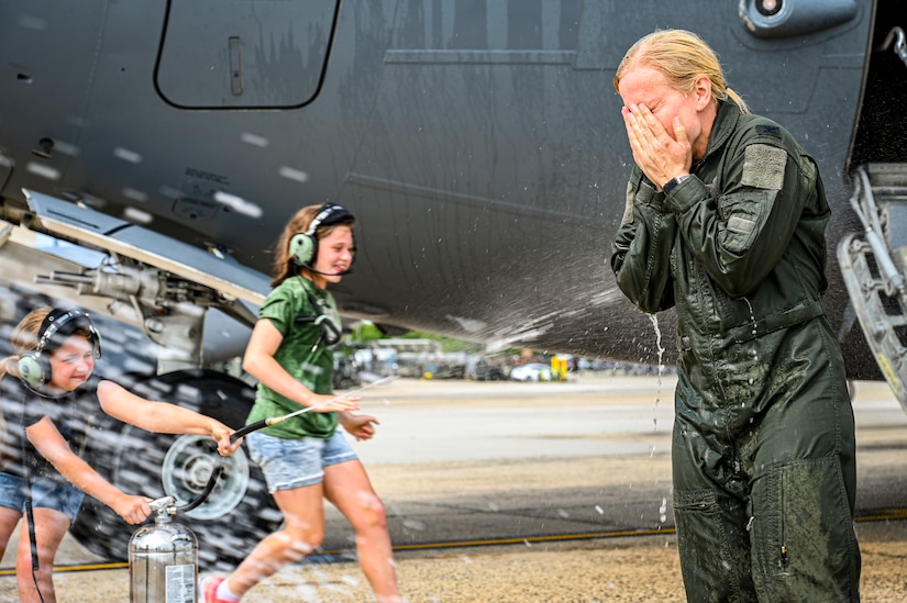 U.S. Air Force Colonel Michele Lo Bianco, 305th Operations Group commander, is sprayed with water by her daughters following a fini flight on June 21, 2022 at Joint Base McGuire-Dix-Lakehurst, N.J. Lo Bianco will serve as the 15th Wing commander at Joint Base Pearl Harbor-Hickam.