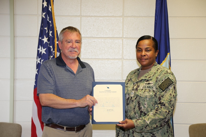 PENSACOLA, Fla. - Naval Education and Training Professional Development Center Commanding Officer, Capt. Willie Brisbane, presents Michael Fisk with an award for winning junior civilian of the quarter (COQ) for first quarter, 2022. Fisk received his award for his superior performance and dedication to duty as a subject matter expert to the Navy Junior ROTC (NJROTC) program’s quarterly instructor salary file business process. (U.S. Navy photo by Cheryl Dengler)