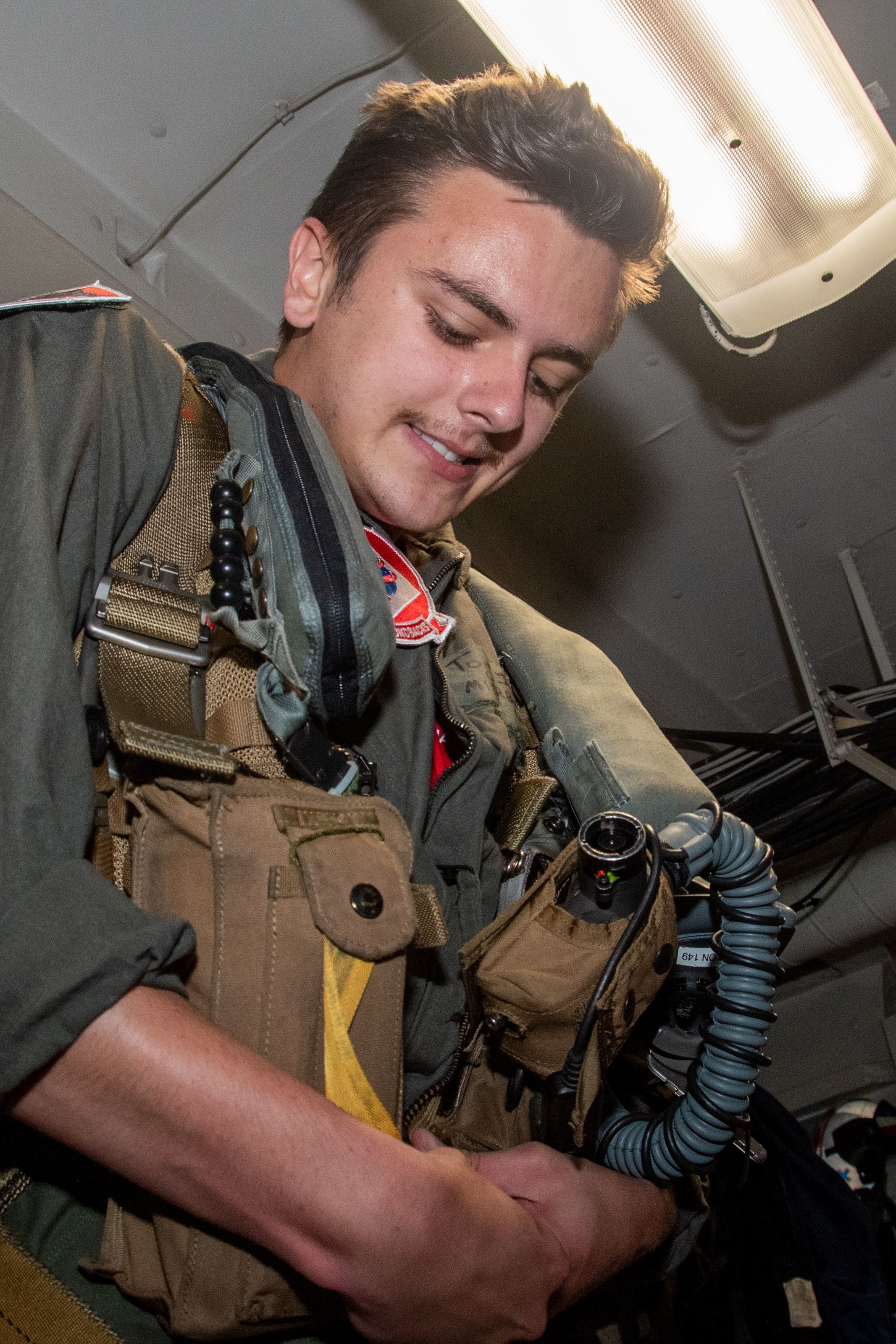 Midshipman 1st Class Tom Joyce puts on survival gear in the Aircrew Survival Equipmentman shop for the “Diamondbacks” of Strike Fighter Squadron (VFA) 102
