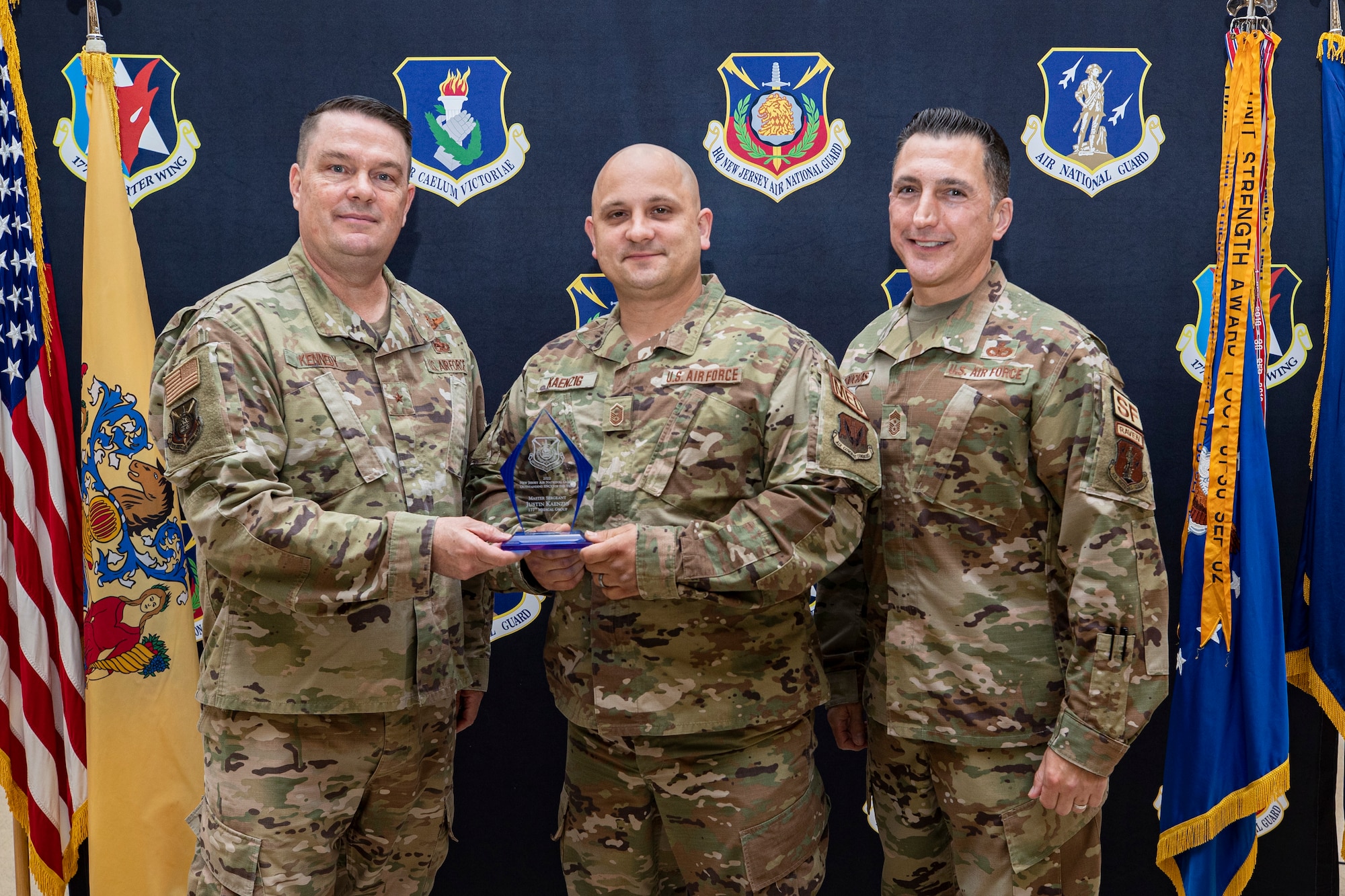 The New Jersey Air National Guard held their annual awards ceremony on Joint Base McGuire-Dix-Lakehurst, New Jersey, June 22, 2022. Master Sgt. Justin Kaenzig, 177th Medical Group, is presented with the 2021 Outstanding SNCO of the Year award by Brig. Gen. Patrick Kennedy and State Command Chief Master Sgt. Michael Rakauckas.