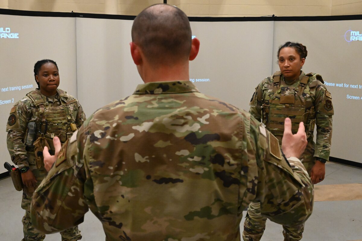 a man instructs two students.