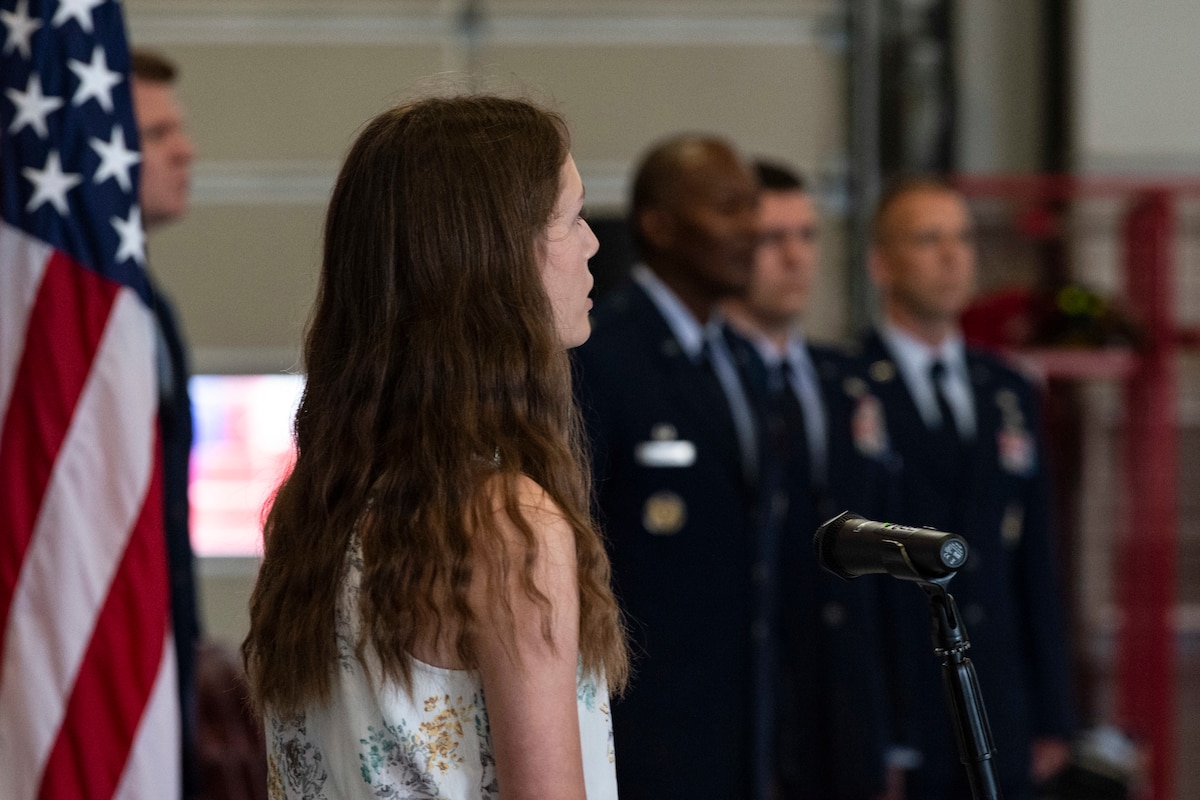 Elizabeth Olson, daughter of Lt. Col. Matthew and Marie Olson, sings the national anthem during the 436th Civil Engineer Squadron Change of Command ceremony held at the base fire station on Dover Air Force Base, Delaware, June 23, 2022. Outgoing commander, Lt. Col. Matthew Olson, relinquished command to Lt. Col. Joshua Yerk. Presiding officer for the ceremony was Col. Phelemon Williams, 436th Mission Support Group commander. (U.S. Air Force photo by Roland Balik)