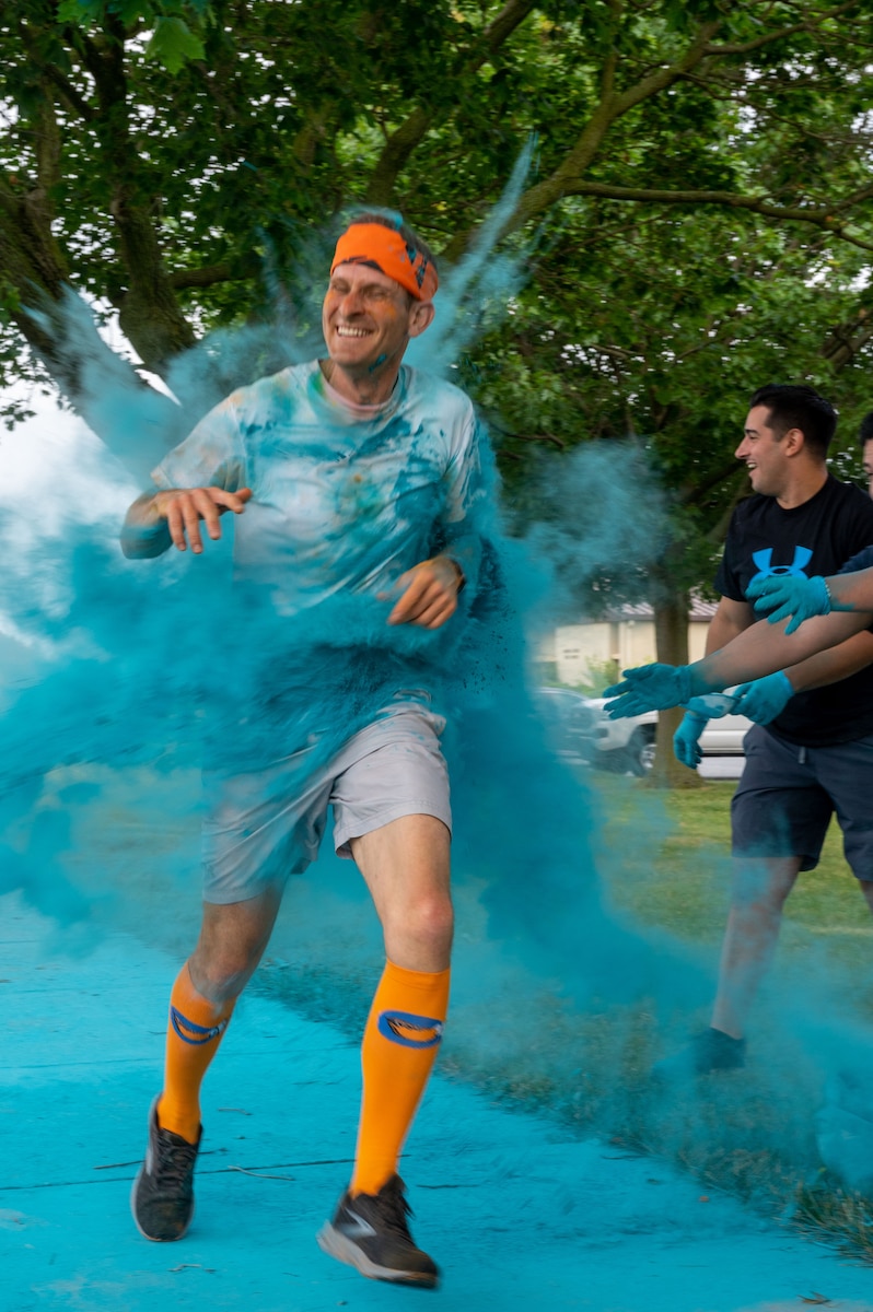 A member of Team Dover gets doused with powder during the Sexual Assault Prevention and Response Color Run at Dover Air Force Base, Delaware, June 24, 2022. SAPR color runs support the implementation of Sexual Assault Awareness Month activities and outreach beyond April. (U.S. Air Force photo by Airman 1st Class Cydney Lee)