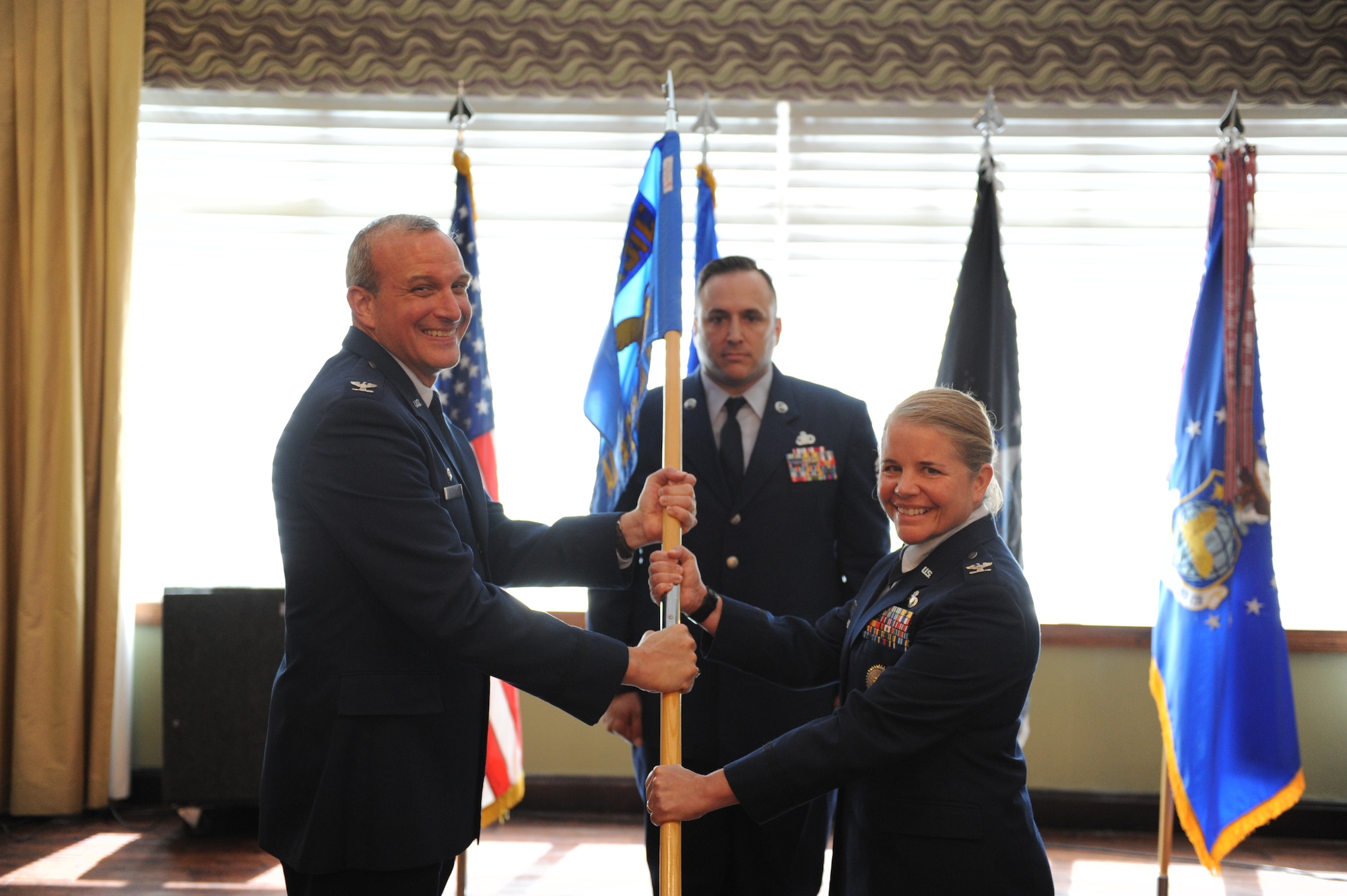 Col. Maurizio Calabrese (left), National Air and Space Intelligence Center commander, presents the ceremonial guidon to Col. Catherine Gambold, inbound Air and Cyberspace Intelligence Group commander, during the group’s change of command ceremony at the Wright-Patterson Club, June 1, 2022. Gambold previously served as the executive officer to the director of the Defense Intelligence Agency. (U.S. Air Force photo by Senior Airman Kristof J. Rixmann)
