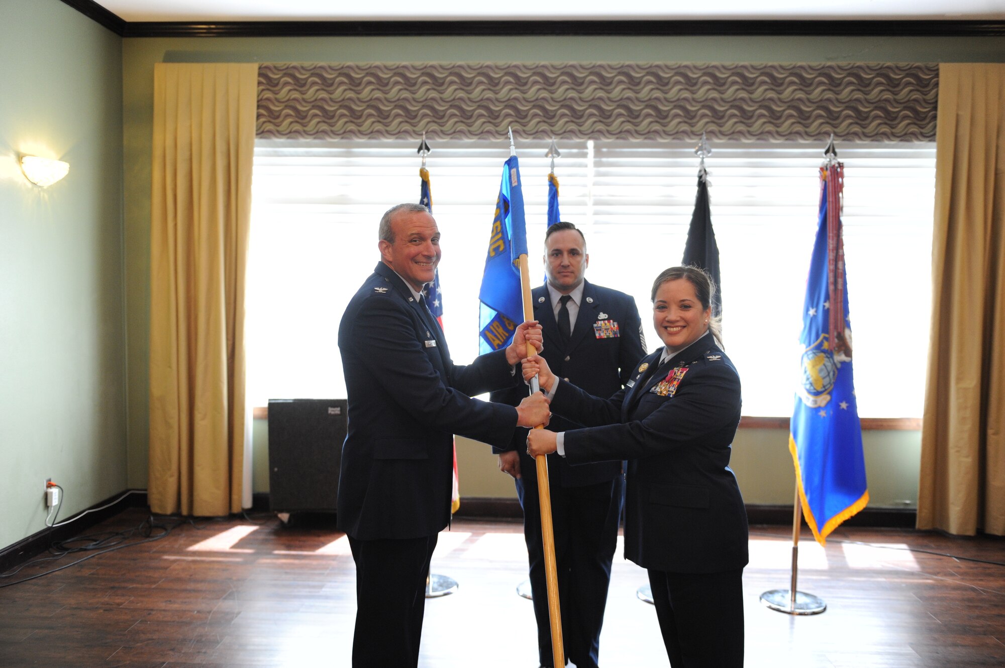 Col. Maurizio Calabrese (left), National Air and Space Intelligence Center commander, receives the ceremonial guidon from Col. Ariel G. Batungbacal, outbound Air and Cyberspace Intelligence Group commander, during the group’s change of command ceremony at the Wright-Patterson Club, June 1, 2022. Batungbacal relinquished command of the group and the next day, took command of National Air and Space Intelligence Center. (U.S. Air Force photo by Senior Airman Kristof J. Rixmann)