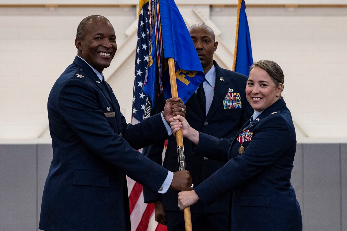 Lt. Col. Kady Griffin, right, outgoing 436th Force Support Squadron commander, relinquishes command of the 436th FSS to Col. Phelemon Williams, left, 436th Mission Support Group commander, during a change of command ceremony held at the base fitness center on Dover Air Force Base, Delaware, June 24, 2022. Team Dover Airmen, family members and guests watched Griffin relinquish command to Lt. Col. Donald Johnson III. Guidon bearer for the ceremony was Master Sgt. Perry Hardy, 436th FSS first sergeant. (U.S. Air Force photo by Roland Balik)