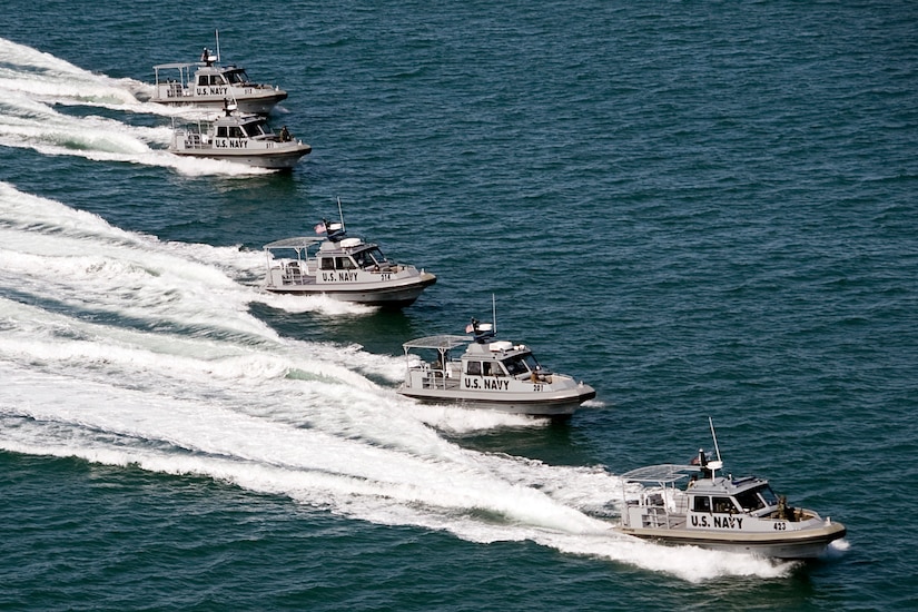 Five boats move through the water.
