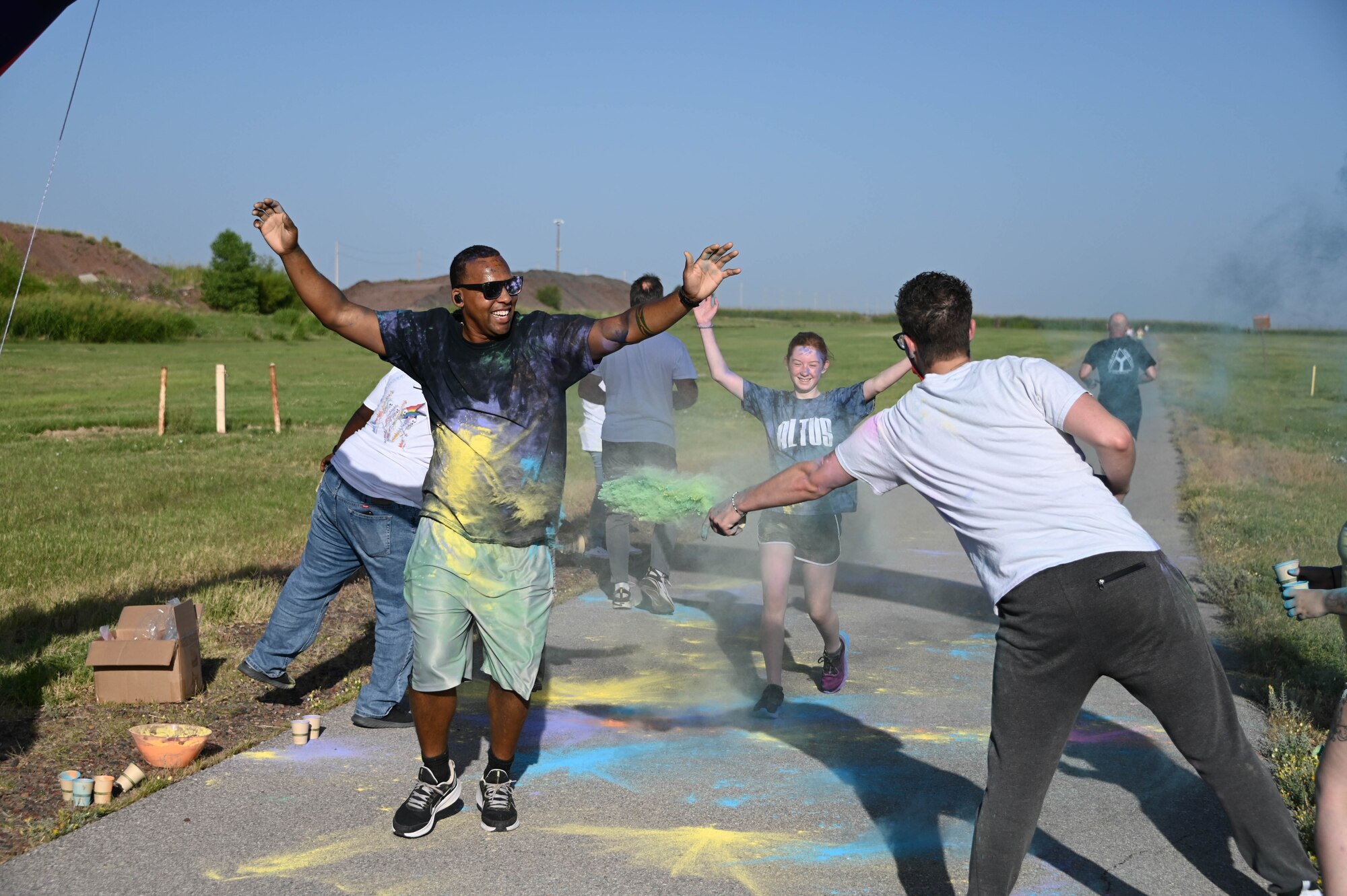 U.S. Air Force Master Sgt. Kenneth Williams-Prades, 97th Force Support Squadron first sergeant, runs through the finish line during the Pride Month color run at Altus Air Force Base, Oklahoma, June 24, 2022. Pride month celebrates the lesbian, gay, bisexual, transgender and queer community, among others. (U.S. Air Force photo by Senior Airman Kayla Christenson)