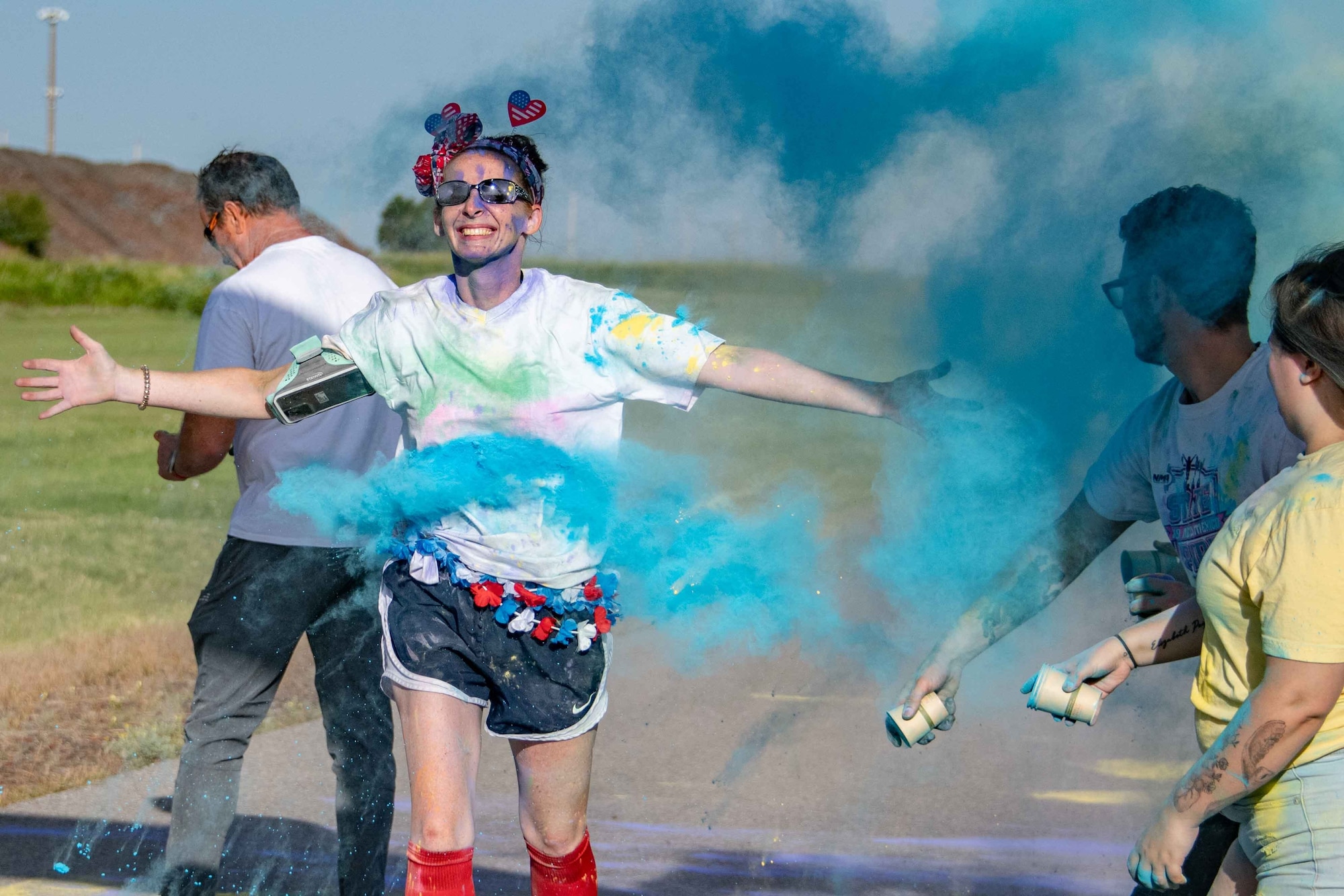 A participant runs through the finish line during the Pride Month color run at Altus Air Force Base, Oklahoma, June 24, 2022. Pride celebrations are credited to Brenda Howard, a bisexual New York activist nicknamed the “Mother of Pride,” who organized the first Pride parade to commemorate the one-year anniversary of the Stonewall Uprising. (U.S. Air Force photo by Staff Sgt. Breanna Klemm)