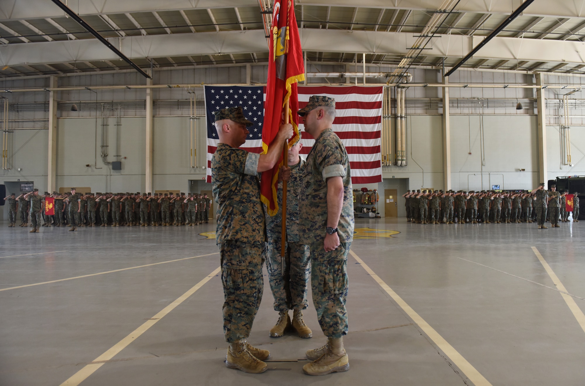 U.S. Marine Corps Lt. Col. Thomas Coyle, left, incoming Marine Corps Detachment commanding officer, receives the Marine flag from Lt. Col. Arturo Derryberry, outgoing MCD commanding officer during the MCD change of command at Goodfellow Air Force Base, Texas, June 24, 2022. The exchanging of the flag physically represents the transfer of responsibility, authority and accountability from outgoing to incoming commanding officer. (U.S. Air Force photo by Airman 1st Class Zachary Heimbuch)