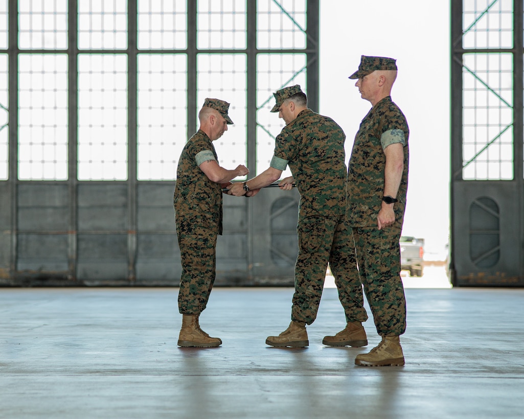 U.S. Marine Corps Sgt. Maj. Thomas R. Coffey, left, receives the non-commissioned officer sword from Lt. Col. Tyler E. Burnham, the Headquarters and Headquarters Squadron (H&HS) commanding officer, signifying his appointment as the new H&HS sergeant major during a relief and appointment ceremony at Marine Corps Air Station Cherry Point, North Carolina, June 24, 2022. The ceremony was held to transition the position of H&HS sergeant major from Sgt. Maj. James I. Petty to Sgt. Maj. Coffey. This event also marked the retirement of Sgt. Maj. Petty after 22 years of honorable service. (U.S. Marine Corps photo by Lance Cpl. Jacob Bertram)