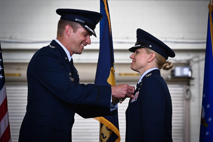 U.S. Air Force Col. Scott Wiederholt pins a decoration on Col. Michele LoBianco
