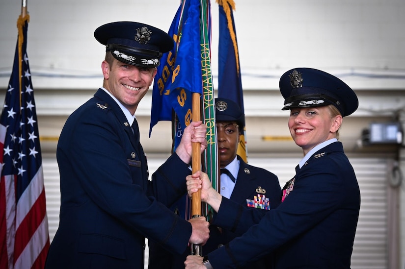 U.S. Air Force Col. Scott Wiederholt receives a guidon from Col. Michele LoBianco