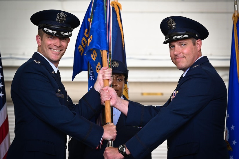 U.S. Air Force Col. Scott Wiederholt passes on a guidon to Col. Jordan P. Norman